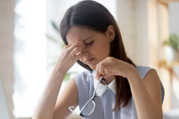 Unavená žena sundat brýle trpí bolestí hlavy — Stock fotografie