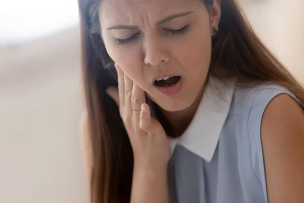 Niezdrowa młoda kobieta dotykać policzek cierpi na ból zęba — Zdjęcie stockowe