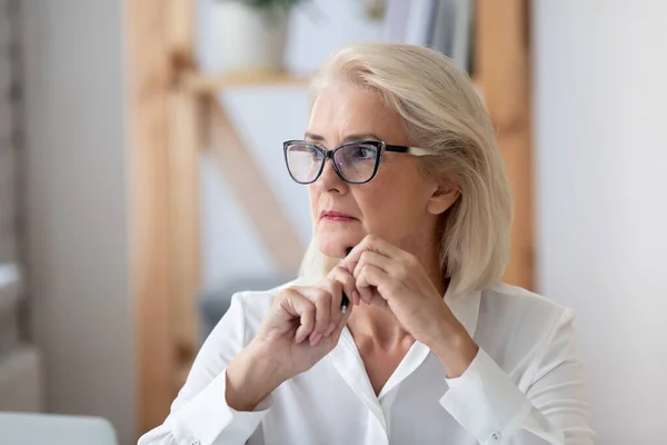 Pensive mature businesswoman look in distance thinking — Stock fotografie