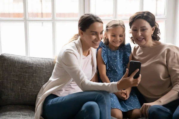 Sorrindo três gerações de mulheres usando celular juntas — Fotografia de Stock