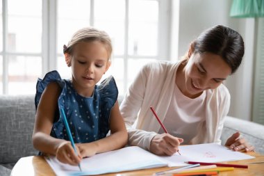 Mutlu anne ve küçük kızı birlikte çiziyorlar.