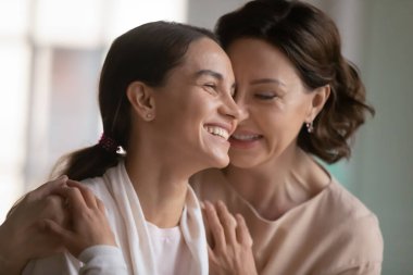 Sevgi dolu orta yaşlı anne yetişkin bir kızı kucaklıyor.