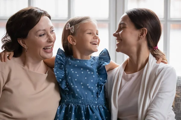 Sorrindo três gerações de mulheres relaxam no sofá juntas — Fotografia de Stock