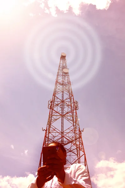 Mulher com smartphone perto da torre de telecomunicações — Fotografia de Stock