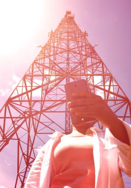 Akıllı telefon telekomünikasyon tower yakınındaki kadınla