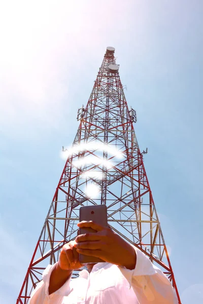 Mulher com smartphone perto da torre de telecomunicações — Fotografia de Stock