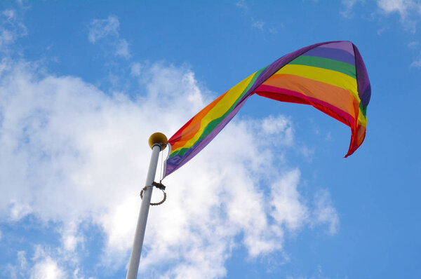 Rainbow flag against blue sky