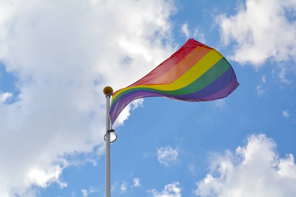 Bandera del arco iris contra cielo azul — Foto de Stock