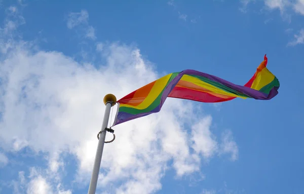 Bandera del arco iris contra cielo azul — Foto de Stock