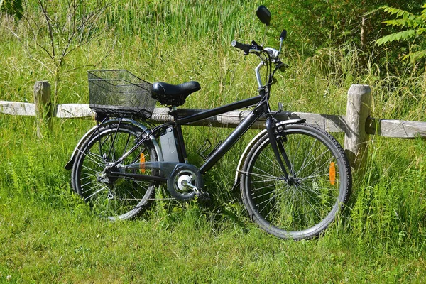 Rower elektryczny na ogrodzenie drewniane — Zdjęcie stockowe