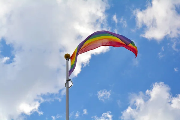Regenboogvlag tegen blauwe hemel — Stockfoto