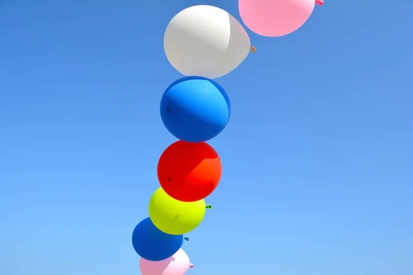 Globos multicolores en el cielo azul — Foto de Stock
