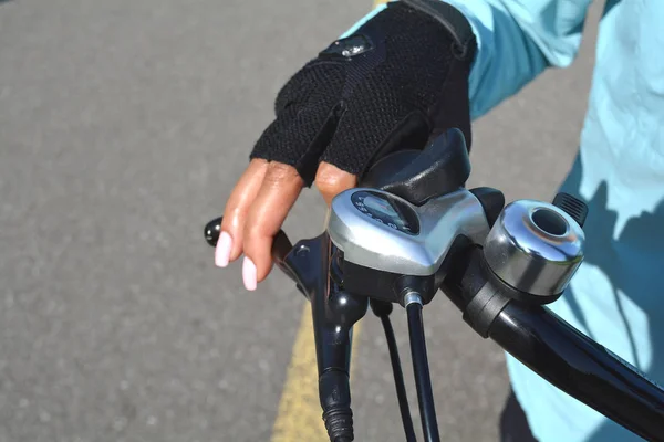 Vrouw hand met helder roze nagels op het handvat van de fiets. — Stockfoto