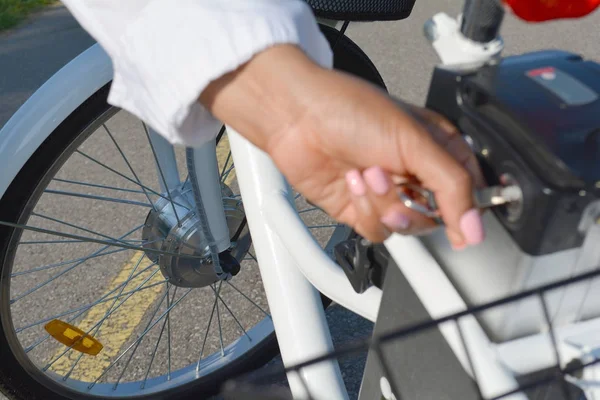 Vrouwen met roze nagels en manicure Houd de toets van de elektrische fiets — Stockfoto