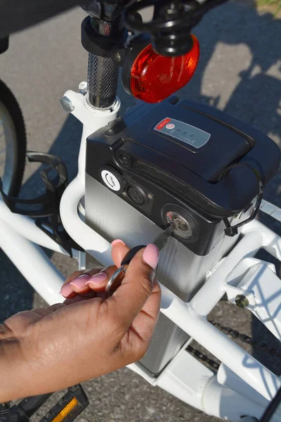 Γυναίκες ποδηλάτης κρατήστε πατημένο το πλήκτρο του ηλεκτρικού ποδηλάτου — Φωτογραφία Αρχείου