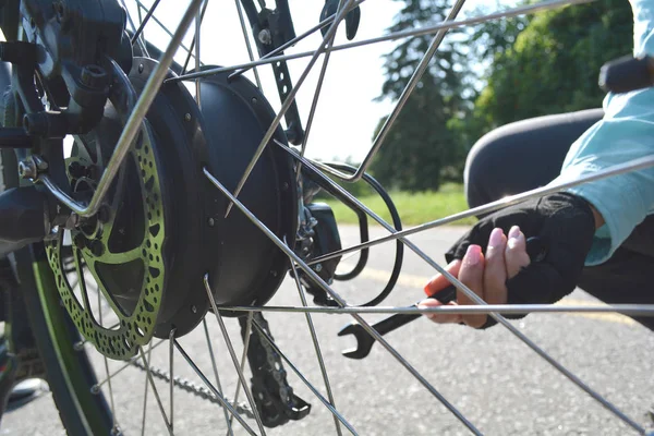 Fitness sport wielrenner vrouw is het repareren van elektrische fiets — Stockfoto