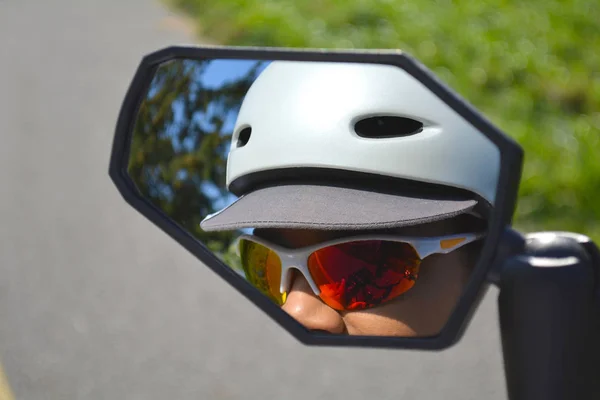 Reflection of woman face in the bicycle mirror. — Stock Photo, Image