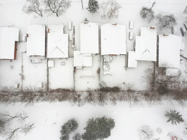 High level of snow storm, winter weather forecast alert day in the city. Top aerial view of people houses covered in snow, bird eye view suburb urban housing development. Quite neighbourhood, Canada.