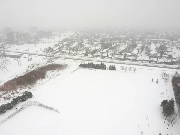 High level of snow storm, winter weather forecast alert day in the city. Top aerial view of people houses covered in snow, bird eye view suburb urban housing development. Quite neighborhood, Canada.