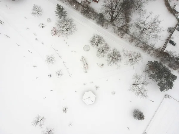 High level of snow and snow storm winter weather forecast alert day in the city. Top aerial view of the kids playground from the bird view. Children\'s park is covered in thick layer of snow. Canada.