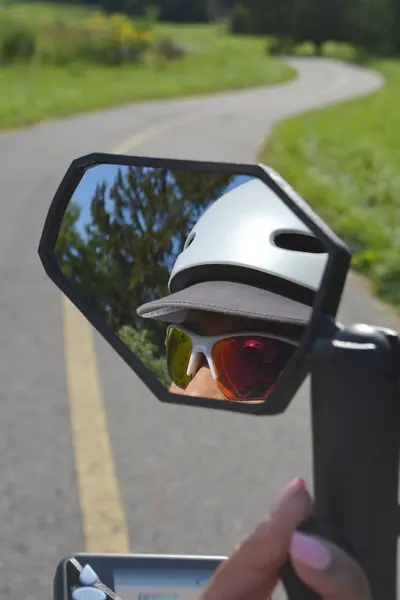 Reflectie van het gezicht van de vrouw in de spiegel van de elektrische fiets. Vrouw — Stockfoto