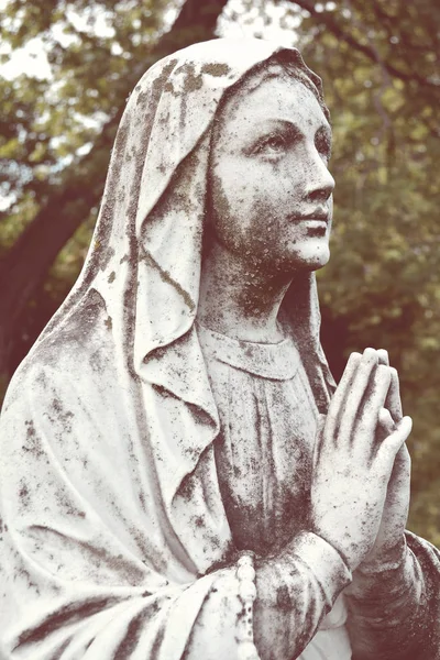 Vintage statue of a suffering Virgin Mary pray. Lady of Sorrow.