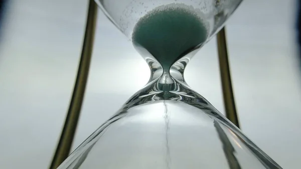 Vista de cerca extrema de la arena que fluye a través de un vaso de una hora. Sup. —  Fotos de Stock