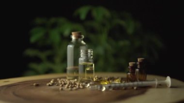 Rotasyona yakından bak ya da eczacılık CBD yağlarına ve ilaçlara bak. Ağız kullanım için kavanozlardaki haplar ve yağlar gibi ahşap masada çeşitli ilaç seçenekleri var. Kenevir bitkisi.
