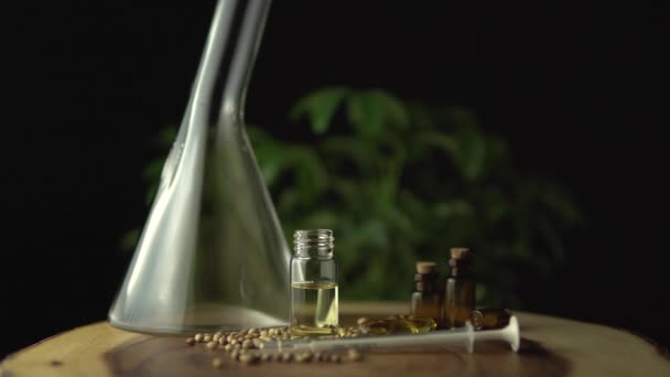 Slow motion macro close up of rotation and spinning of glass jars with cbd oil and seeds. Hydroponic and aquaponic of biological and ecological cannabis hemp plant, herbal pharmaceutical. — Stock Video
