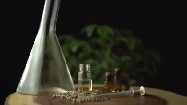 Slow motion macro close up of rotation and spinning of glass jars with cbd oil and seeds. Hydroponic and aquaponic of biological and ecological cannabis hemp plant, herbal pharmaceutical. — Stock Video