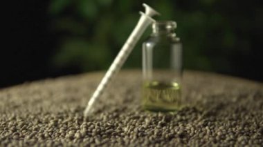 Kenevir tohumu ve yeşil marihuana bitkisi arka planında tıbbi marihuana CBD yağı ve ağız şırıngası var. Odaklan ya da yana kay. Acı tedavisinde ve iyileşmede devrim.