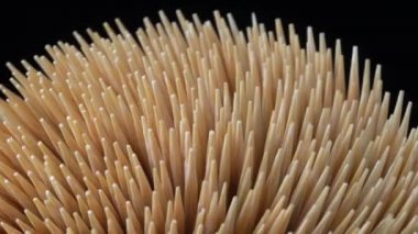 Kürdan siyah arka plan rotasyonunda. Kokteyl çubuğu ya da kürdan makro odağı merkeze. Diş hijyeni ya da diş bakımı kavramı. Kariyer önleme. Diş Sağlığı Hizmetleri.