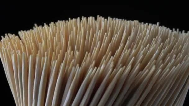 Macro close-up de palitos de bambu de madeira, rotação de movimento lento a partir do lado. Conceito de higiene dos dentes pessoais ou cuidados dentários orais após a refeição. Prevenção de cáries. Saúde dentária. — Vídeo de Stock