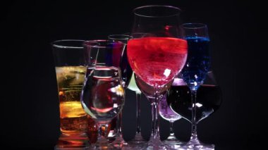 Bardakta içki var. Renkli kokteyl ve içeceklerle bir sürü şekillendirilmiş bardak. Gece kulübü konseptinde şık bir bar. Gece kulübü yaşam tarzı. Yeni yıl ya da Noel kutlaması.