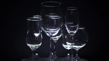Şarap için farklı şekilli boş bardakları olan gece kulübü tezgahı barda ağır çekimde dönen. Noel ya da yeni yıl partisi konsepti. Kapat..