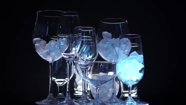 Discoteca con diferentes vasos vacíos en forma de hielo para un vino de cámara lenta girando en el bar. Navidad o Año Nuevo concepto de humor de fiesta. De cerca. . — Vídeo de stock