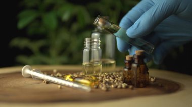 Cam kavanoz şişesini kenevir cbd yağıyla dolduruyorum.