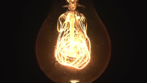 Wolfram-Glühbirne Lampe gemütlich Dimmen über schwarzem Hintergrund, Makro Nahaufnahme von alten Retro-Vintage-Glühbirne schalten Sie das Licht aus. Gemütliches Konzept. 4k. — Stockvideo
