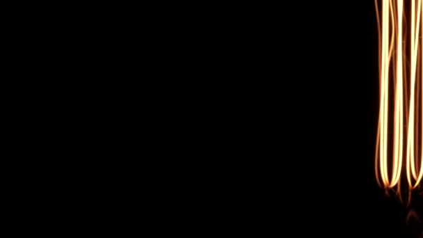 Tungsten gloeilamp bokeh onthullende details tijdens het roteren op zwarte achtergrond. Vintage Edison gloeilamp draaiend en bewegend in het donker, toont van scherpe heldere draden binnen. 4k. — Stockvideo