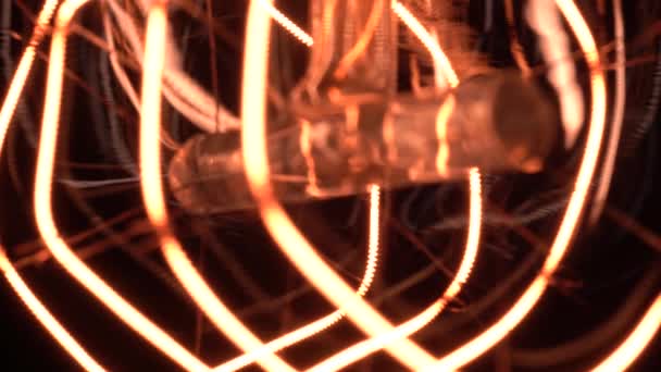 Extreme macro binnenkant van Edison gloeilamp langzaam onthullen in focus en details tijdens het flikkeren. Schuiven onder vintage gloeilamp gloeien en dimmen close-up zicht van onderen met bokeh effect. 4k. — Stockvideo