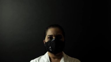 Siyah maske takan Afro-Amerikalı bir kadın kafasına taç ya da taç takıyor. Covid-19 enfeksiyon konsepti. Ölümcül Corona virüsü 2019-Ncov, Çin konseptinde salgın.
