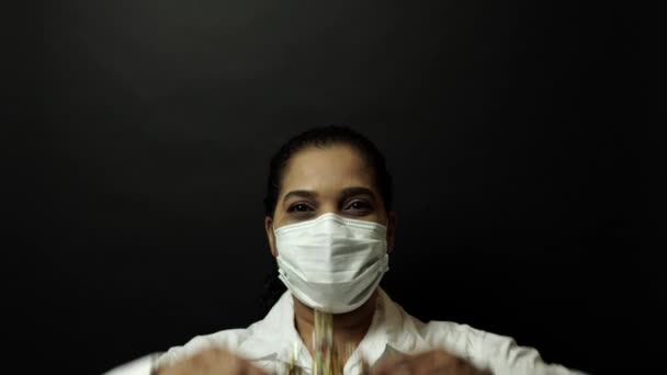 Женщина в хирургической или медицинской маске надевает корону на голову, изображая коронавирус или ковид 19, концепцию вспышки вируса. Короновирусная болезнь 2019-nCoV защита и профилактика. 4k . — стоковое видео