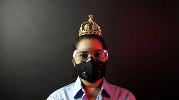 Woman in urban protective air mask with glasses, wearing crown o