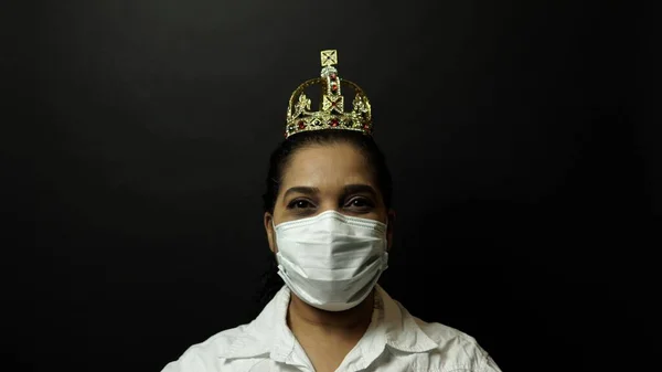 Woman in surgical or medical mask put on the crown on the head, — Stock Photo, Image