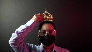 Woman in urban protective air mask with glasses, wearing crown or corona. Coronavirus pathogen outbreak pandemic concept. Virus disease 2019-nCoV or covid-19 protection and prevention. 4k