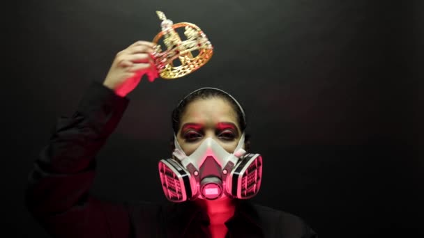 Woman in the heavy duty biohazard medical mask put the crown or corona on the head. Personal forced home quarantine isolation from Coronavirus or covid 19 concept. Apocalypses and depression mood. — 图库视频影像