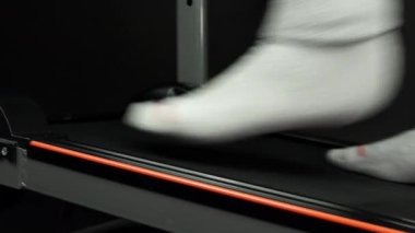 Erkek ayağı koşu bandında yürür, vücudu formda ve formda tutmak için. Kilo kaybederken bir insanın yan bacaklarını kapatın. Spor salonunda kişisel spor yaşam tarzı ve fitness kavramı.