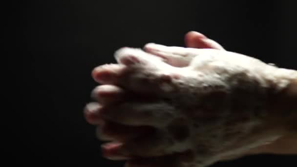 Man washes his hands with soap at black background to eliminate germs and protect against the coronavirus. Personal hygiene. Close up of cleansing the skin. Disease COVID 19 self prevention. — Stock Video