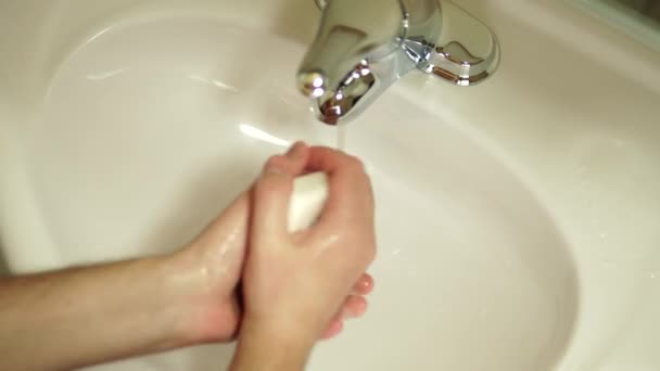 Close-up de um homem de lathering mãos com tijolo de sabão e água enxaguando na pia do banheiro branco. Bem-estar da saúde e conceito de cuidado corporal . — Vídeo de Stock