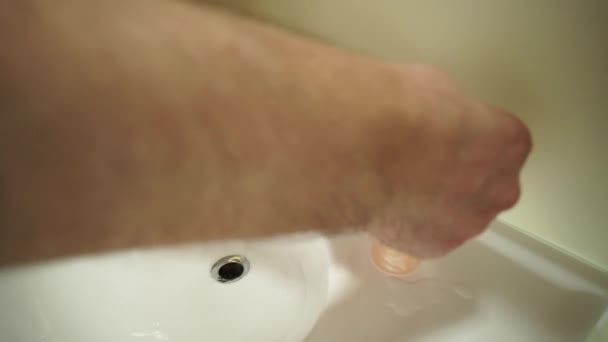 Persoon die zijn handen wast in een witte waskom of gootsteen met vloeibare zeep of schuim. Reiniging van de handen huid zeer zorgvuldig en grondig tot zeepbellen. Gezondheid en schoonheid. — Stockvideo